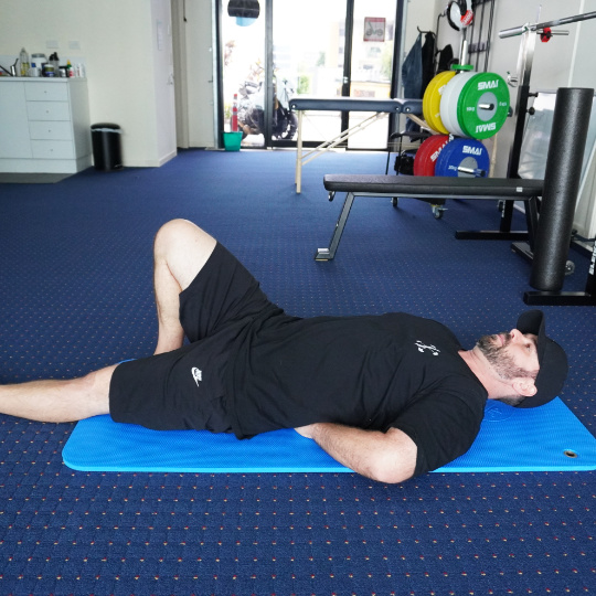 McGillCurlUp540 - Brisbane Back Pain Program | McGill Certified Practitioner | Online Coaching Photo of a McGill Curl-up exercise.