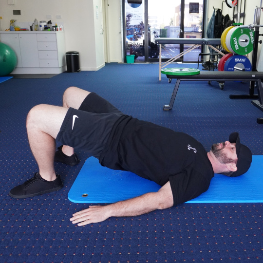 Glute-bridge540 - Brisbane Back Pain Program | McGill Certified Practitioner | Online Coaching Photo of a glute bridge exercise.